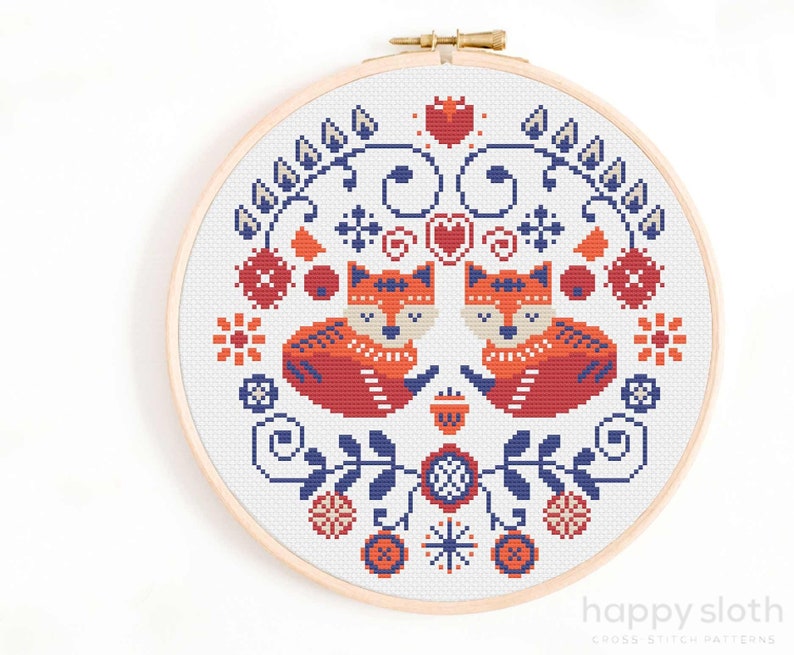 a cross stitch picture of two foxes in a circle