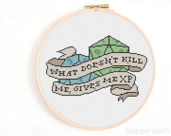 May include: A cross-stitch pattern featuring a banner with the text "What doesn't kill me, give me XP" and a stack of dice.