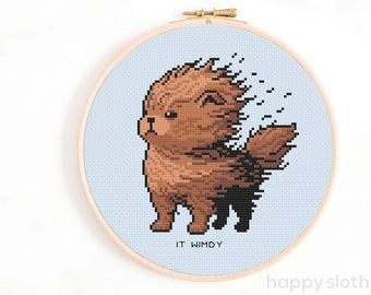 May include: Cross stitch pattern of a brown dog with its fur blowing in the wind. The pattern is on a blue background and includes the text "IT WIMDY".