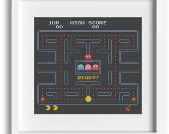 May include: A pixelated cross-stitch pattern of the classic arcade game Pac-Man. The pattern features the Pac-Man maze with Pac-Man and the ghosts in their iconic colors. The text "READY!" is displayed in the center of the maze.