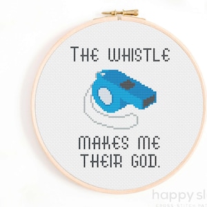 May include: Cross stitch pattern on a white fabric with a blue whistle and the text "The whistle makes me their god."