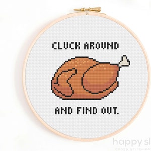 Peut inclure: Un cerceau de broderie blanc avec un motif de point de croix représentant une dinde rôtie brune avec le texte "CLUCK AROUND AND FIND OUT."
