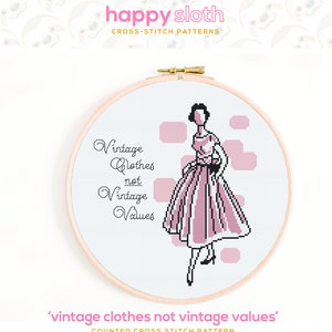 May include: A cross-stitch pattern featuring a woman in a pink dress with the text 'Vintage Clothes not Vintage Values'.