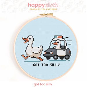 May include: A cross-stitch pattern in a wooden hoop features a pixelated duck running from a police car, also driven by a duck. The text "GOT TOO SILLY" is below the image. The pattern is on a light blue background.