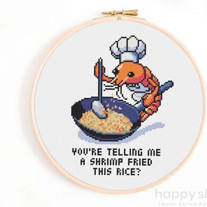 Puede incluir: Un patrón de punto de cruz con una gamba de dibujos animados que lleva un gorro de cocinero y remueve un wok de arroz. El texto dice "¿Me estás diciendo que una gamba ha frito este arroz?"