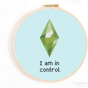May include: A cross-stitch pattern featuring a green diamond with the text "I am in control." on a light blue background.