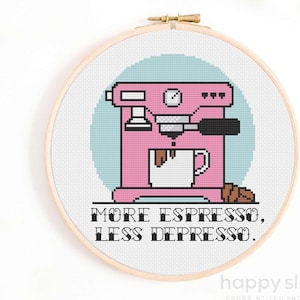 Könnte beinhalten: Kreuzstich-Stickerei mit einer rosa Espressomaschine, einer weißen Kaffeetasse, Kaffeebohnen und dem Text "MORE ESPRESSO, LESS DEPRESSO." Das Design ist vor einem hellblauen Kreis platziert und in einem Holzreifen gerahmt.