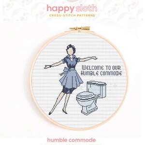 May include: A counted cross stitch pattern featuring a woman in a blue dress standing next to a toilet with the text "Welcome to our humble commode".