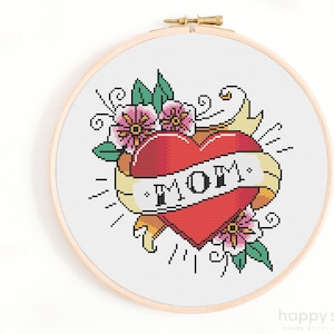 Puede incluir: Patrón de punto de cruz con un corazón rojo con una pancarta que dice "MOM" rodeado de flores rosas y hojas verdes.