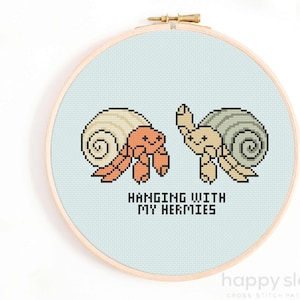 May include: Cross stitch pattern featuring two cartoon hermit crabs in shells with the text "Hanging with my hermies".