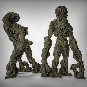 May include: Two green, detailed, humanoid figures with multiple appendages and a textured, organic appearance. The figures are sculpted in a standing pose.