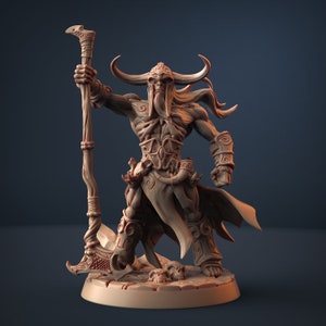 May include: A detailed miniature figurine of a horned, skeletal warrior with a long beard, holding a staff with a blade at the end. The figurine is painted in a brown color and stands on a circular base.