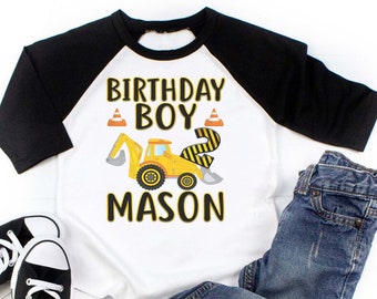 May include: A white and black baseball tee shirt with a yellow construction vehicle graphic. The shirt says "Birthday Boy" and "Mason" in black text. The number "2" is on the side of the vehicle.