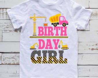 May include: White t-shirt with a pink and yellow construction themed design. The text reads "1st Birthday Girl" with a crane, dump truck, and excavator graphics.