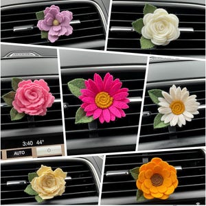 May include: Assortment of felt flower car air freshener designs.  The flowers are pink, white, yellow, orange, and purple.  The flowers are attached to a metal clip that can be used to hang the air freshener from a car vent.