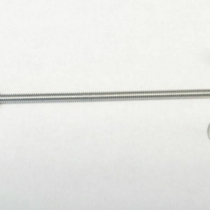 May include: A stainless steel threaded rod with a nut, washer, and a cap nut. The rod is approximately 10 inches long. The hardware is designed for construction or repair projects.
