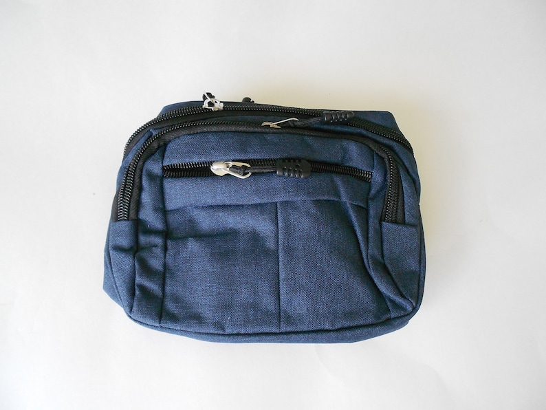 May include: A dark blue fanny pack with black zippers and a silver zipper pull.