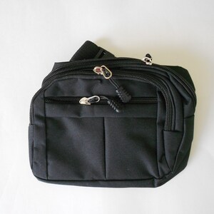 May include: Black fanny pack with multiple zippered compartments and an adjustable strap.