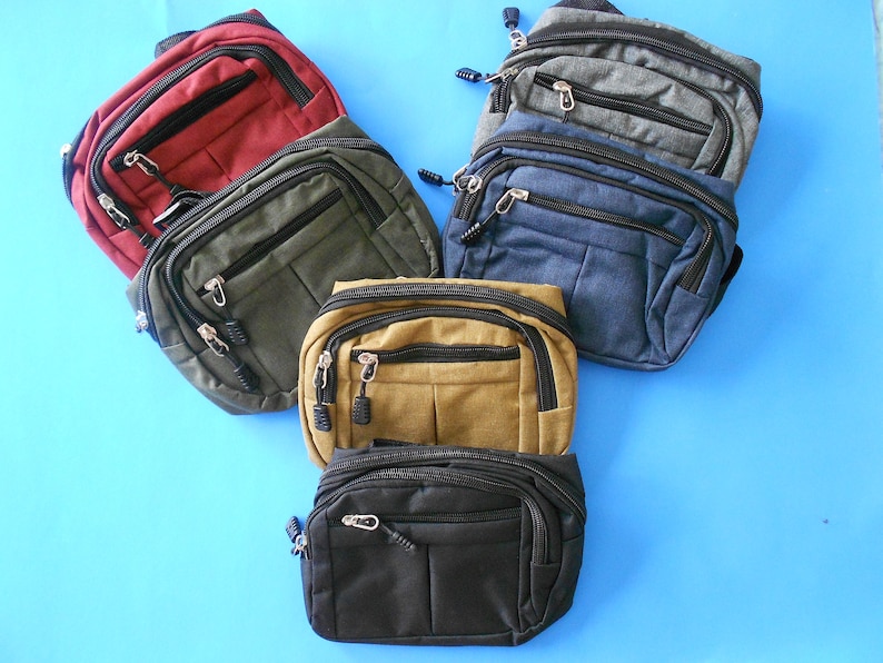 May include: Six fanny packs in different colors, including red, green, brown, black, blue, and gray. The fanny packs have multiple zippered compartments and are made of a durable fabric.