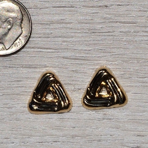 May include: A pair of gold triangle earrings with a woven design.