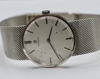 May include: A silver Omega wristwatch with a white face and a silver mesh band.