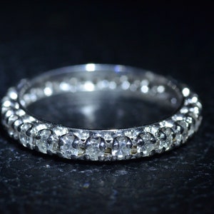 May include: A silver band ring with a row of small, clear gemstones.