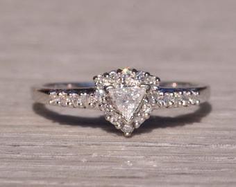 Könnte beinhalten: Ein silberner Ring mit einem dreieckigen Diamanten, der in einem Heiligenschein aus kleineren Diamanten gefasst ist.