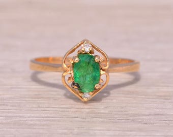 Anillo de esmeraldas y diamantes naturales en oro amarillo.