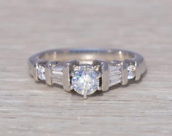 Anel de noivado vintage em platina com diamantes redondos e baguete.