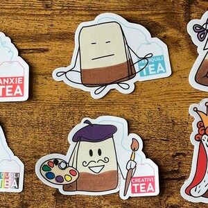 Può includere: Set di 10 adesivi a forma di bustina di tè con diversi design e frasi. Ogni adesivo presenta una bustina di tè con un viso e un'etichetta che dice "TEA". Le frasi sulle etichette includono "Anxie Tea", "Equili Tea", "Tranquili Tea", "Craf Tea", "Creativi Tea" e "Royal Tea".