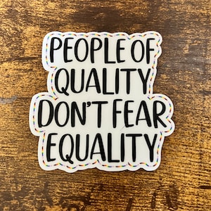 Può includere: Un adesivo bianco con un bordo arcobaleno e il testo "People of Quality Don't Fear Equality".