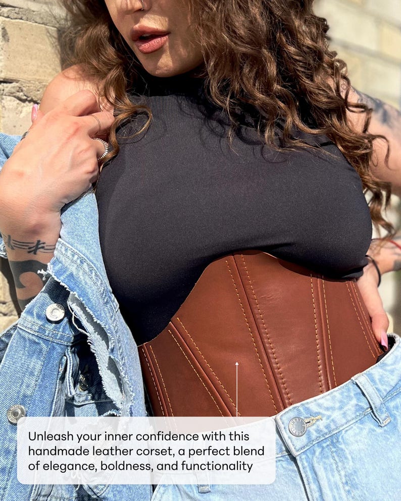 May include: A brown leather corset with vertical stitching and a curved shape. The corset is worn over a black top and under a denim jacket. The image includes the text: "Unleash your inner confidence with this handmade leather corset, a perfect blend of elegance, boldness, and functionality."