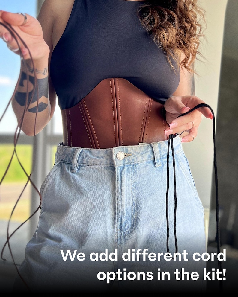 May include: A brown leather corset with a black top and light blue jeans. The corset has vertical stitching and a cinched waist. The image includes the text: "We add different cord options in the kit!"