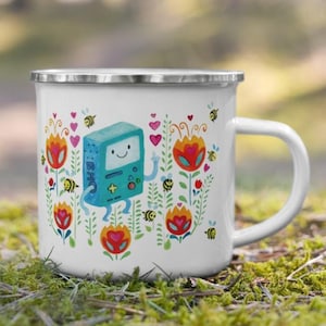 May include: A white enamel mug with a blue and green cartoon character, surrounded by colorful flowers and bees. The mug has a silver rim and handle.