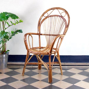 May include: A brown wicker chair with a high back and arms, featuring a unique fan-shaped design. The chair is sitting on a black and white chequered floor.