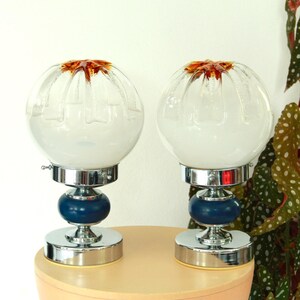 May include: Pair of vintage table lamps with white glass shades, blue bases, and chrome accents.