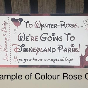 K&ouml;nnte beinhalten: Eine ros&eacute;goldene Karte im Ticketstil k&uuml;ndigt eine Reise nach Disneyland Paris an. Die Karte enth&auml;lt den Text "Happy Birthday", "Love Mummy & Daddy" und "We're Going To Disneyland Paris!" mit einer Mickey Mouse Silhouette.