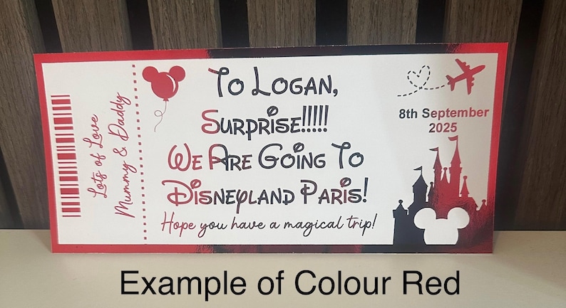 K&ouml;nnte beinhalten: Eine rot-wei&szlig;e Ticket-Ank&uuml;ndigung mit dem Text "To Logan, Surprise! We are going to Disneyland Paris!" und dem Datum "8. September 2025". Enth&auml;lt eine Mickey Mouse Silhouette und ein rotes Flugzeug.