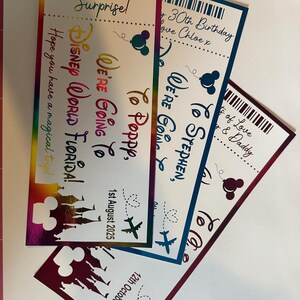 Op de afbeelding: Drie kleurrijke verrassingstickets met de tekst: "Disney World Florida!", "We're Going To Poppy" en "We're Going To Stephen". Elk ticket heeft een Mickey Mouse silhouet en een vliegtuig. Data staan op de tickets.
