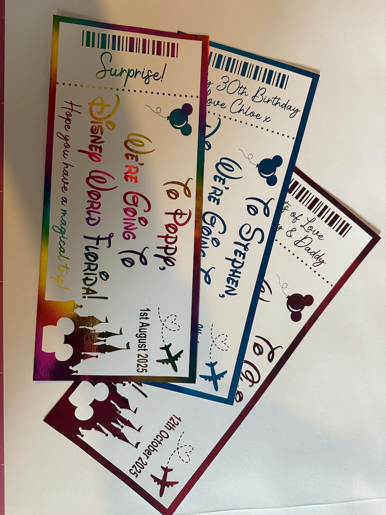 Op de afbeelding: Drie kleurrijke verrassingstickets met de tekst: "Disney World Florida!", "We're Going To Poppy" en "We're Going To Stephen". Elk ticket heeft een Mickey Mouse silhouet en een vliegtuig. Data staan op de tickets.