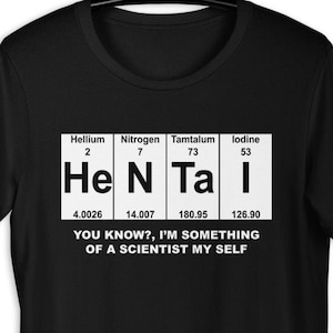 Puede incluir: Camiseta negra con un gr&aacute;fico blanco de los elementos de la tabla peri&oacute;dica Helio, Nitr&oacute;geno, T&aacute;ntalo y Yodo, deletreados como "He N Ta I". El texto "You know?, I'm something of a scientist my self" est&aacute; debajo del gr&aacute;fico.