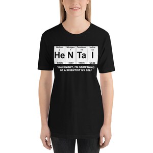 Puede incluir: Camiseta negra con un gr&aacute;fico blanco de la tabla peri&oacute;dica que presenta los elementos Helio, Nitr&oacute;geno, T&aacute;ntalo y Yodo. El gr&aacute;fico dice "He N Ta I" e incluye los n&uacute;meros at&oacute;micos y los pesos de cada elemento. El texto debajo del gr&aacute;fico dice "&iquest;Sabes?, soy algo de un cient&iacute;fico yo mismo."