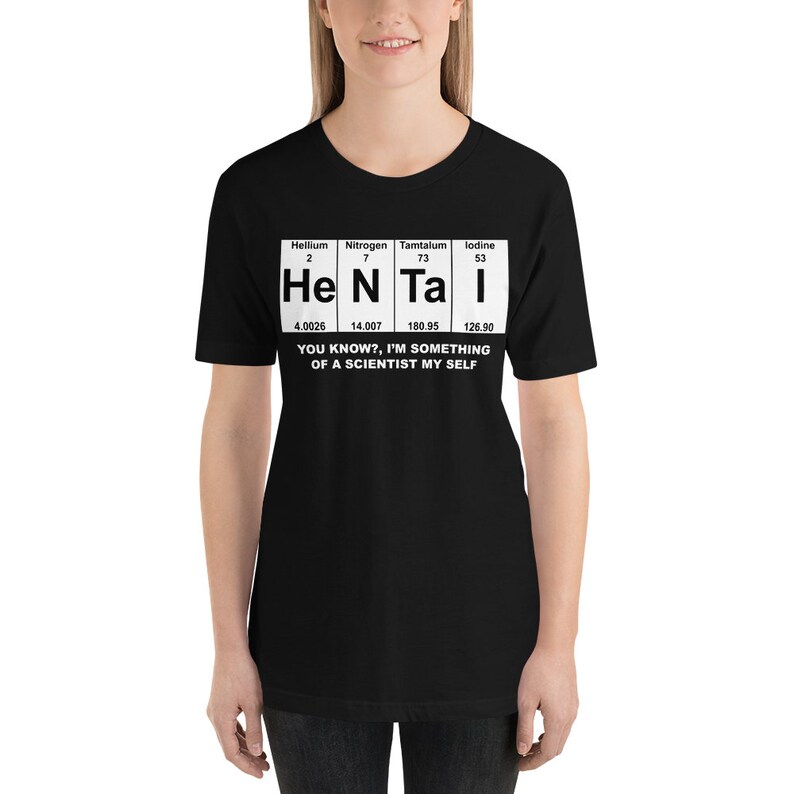 Puede incluir: Camiseta negra con un gr&aacute;fico blanco de la tabla peri&oacute;dica que presenta los elementos Helio, Nitr&oacute;geno, T&aacute;ntalo y Yodo. El gr&aacute;fico dice "He N Ta I" e incluye los n&uacute;meros at&oacute;micos y los pesos de cada elemento. El texto debajo del gr&aacute;fico dice "&iquest;Sabes?, soy algo de un cient&iacute;fico yo mismo."