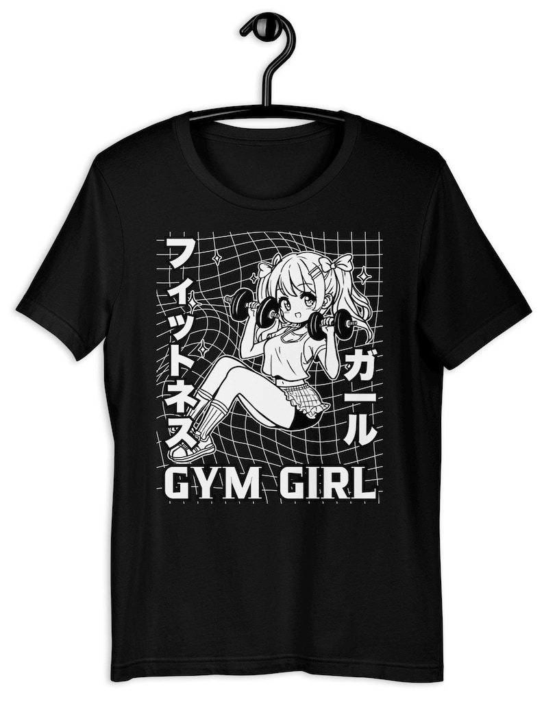 A black t-shirt is shown with a white graphic of a kawaii anime girl lifting weights. The text on the shirt reads 'Gym Girl' in English and ''Fitness Girl'' in Japanese. It's a perfect gift for otaku who love Japanese cartoons and strength training.