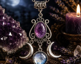 May include: A silver-toned pendant necklace featuring an oval purple amethyst stone set above a circular iridescent moonstone, flanked by two silver crescent moons. The metalwork includes intricate scroll patterns and a decorative bail.