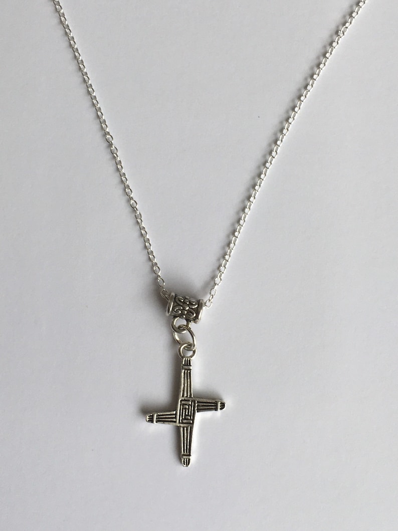 May include: A silver chain necklace with a silver Celtic cross pendant.