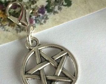 May include: Silver charm with a pentagram design. The charm has a lobster clasp for attaching to a bag, keychain, or other items.