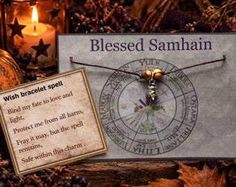 May include: A brown cord bracelet with two gold-toned beads and a small silver-toned charm, attached to a display card featuring a wheel of the year design and the text Blessed Samhain, alongside a card with the printed text Wish bracelet spell.