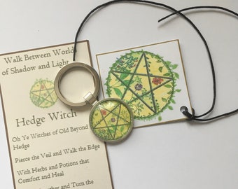 May include: A silver key chain with a round charm featuring a green pentacle with a yellow background. The charm is surrounded by a green leafy border. The key chain is accompanied by a card with the text "Walk Between Worlds of Shadow and Light" and "Hedge Witch". The card also includes a poem about hedge witches.