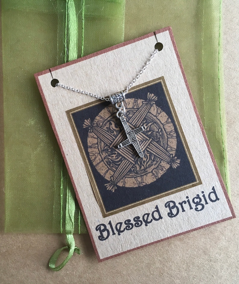 May include: A silver necklace with a Celtic cross pendant. The pendant is on a card with the text "Blessed Brigid".